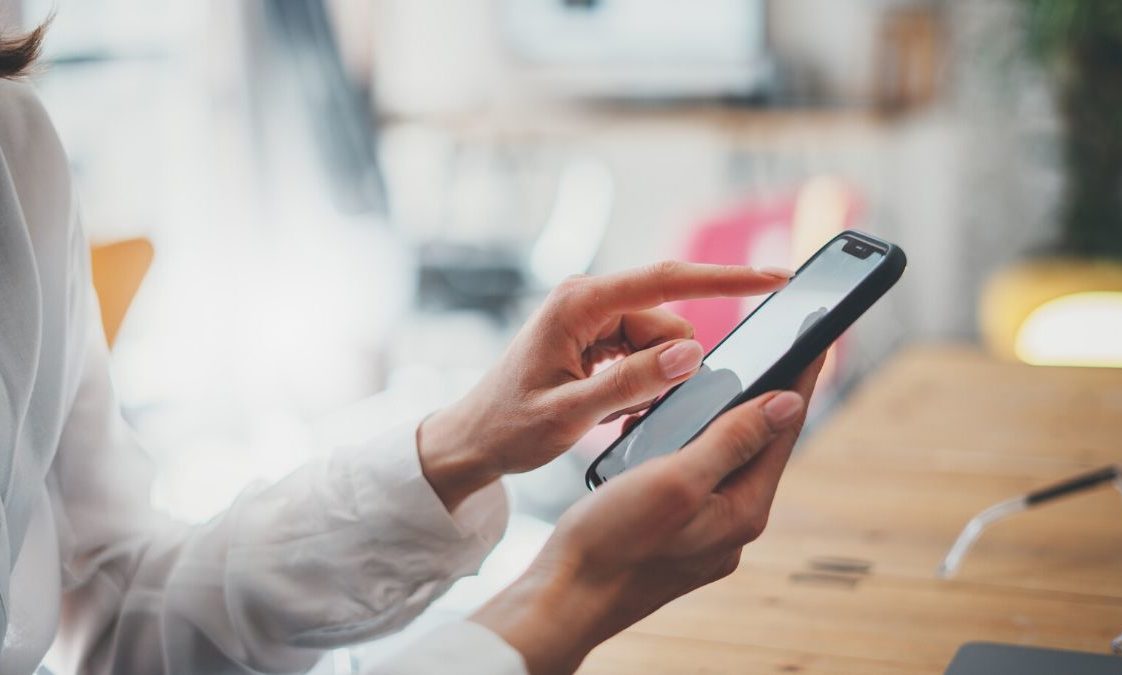 woman with hands on her android phone