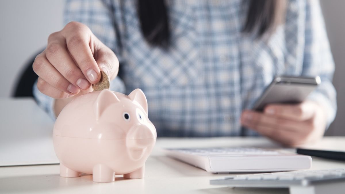 woman putting money into a piggy bank