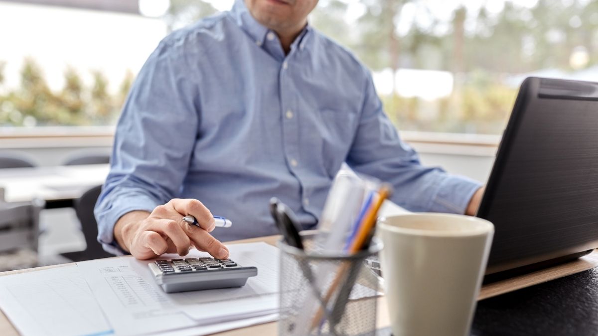 man at a desk with a calculator and printed pages