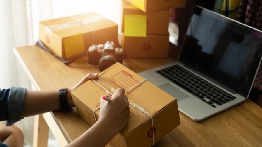 woman writing on a package to ship out
